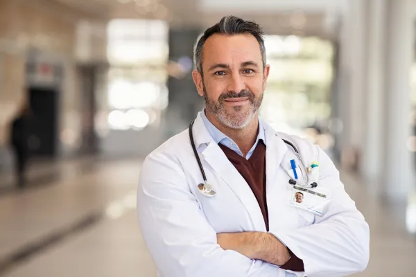 a harper md physician smiling with his arms crossed