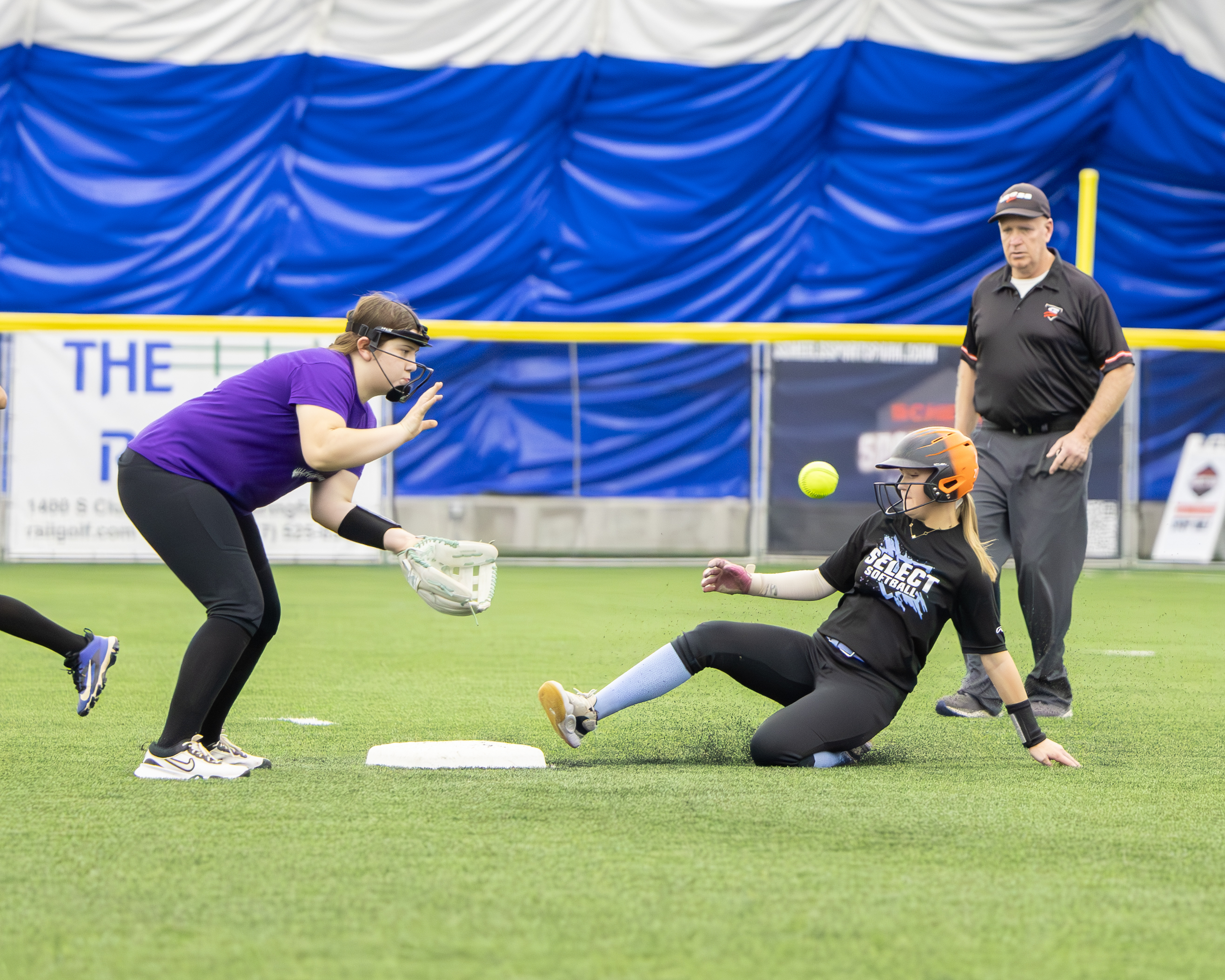 Softball image of female sliding into home plate.