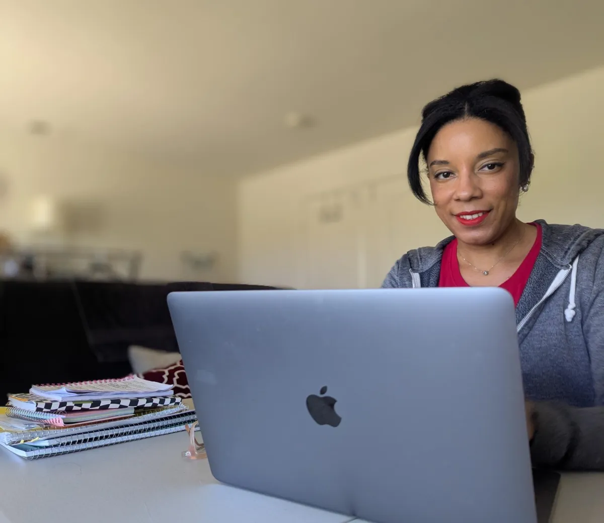 woman typing on computer and smiling at camera