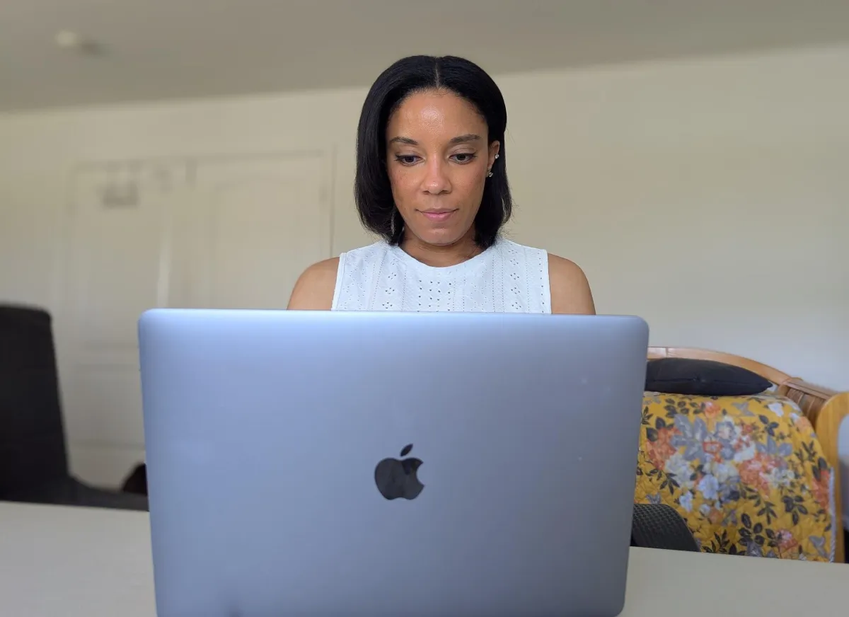woman typing on apple computer