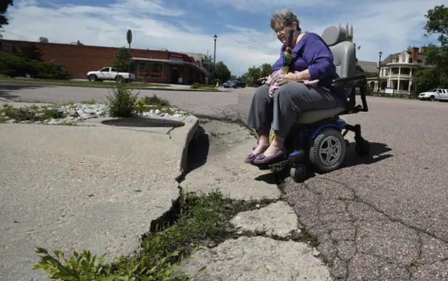 woman in wheelchair unable to get over sidewalk curb