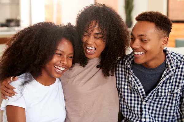 A family hugging, showing support for their LGBTQ+ child.