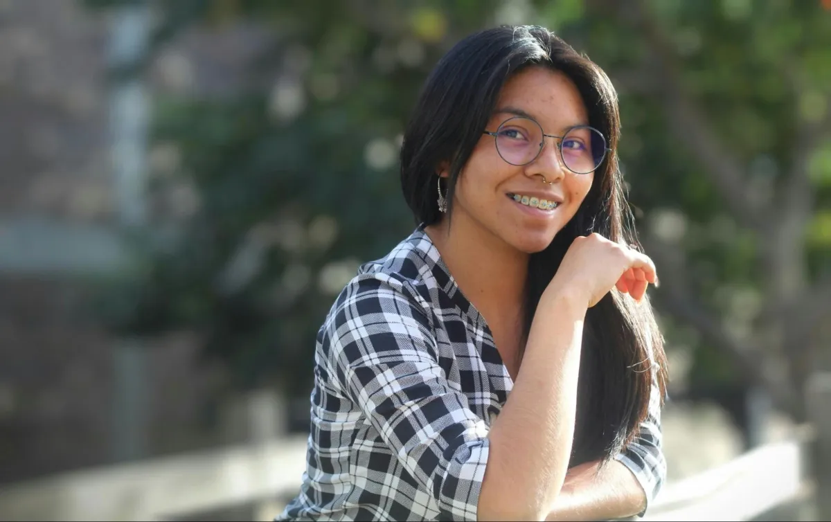 Young Woman Smiling Outdoors in Casual Wear