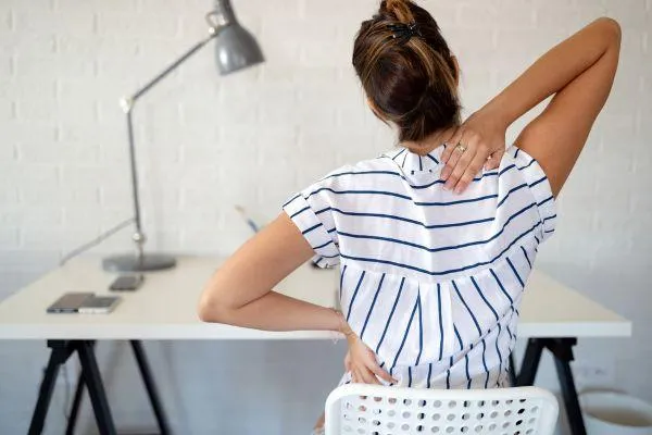 woman seated at desk with bad posture
