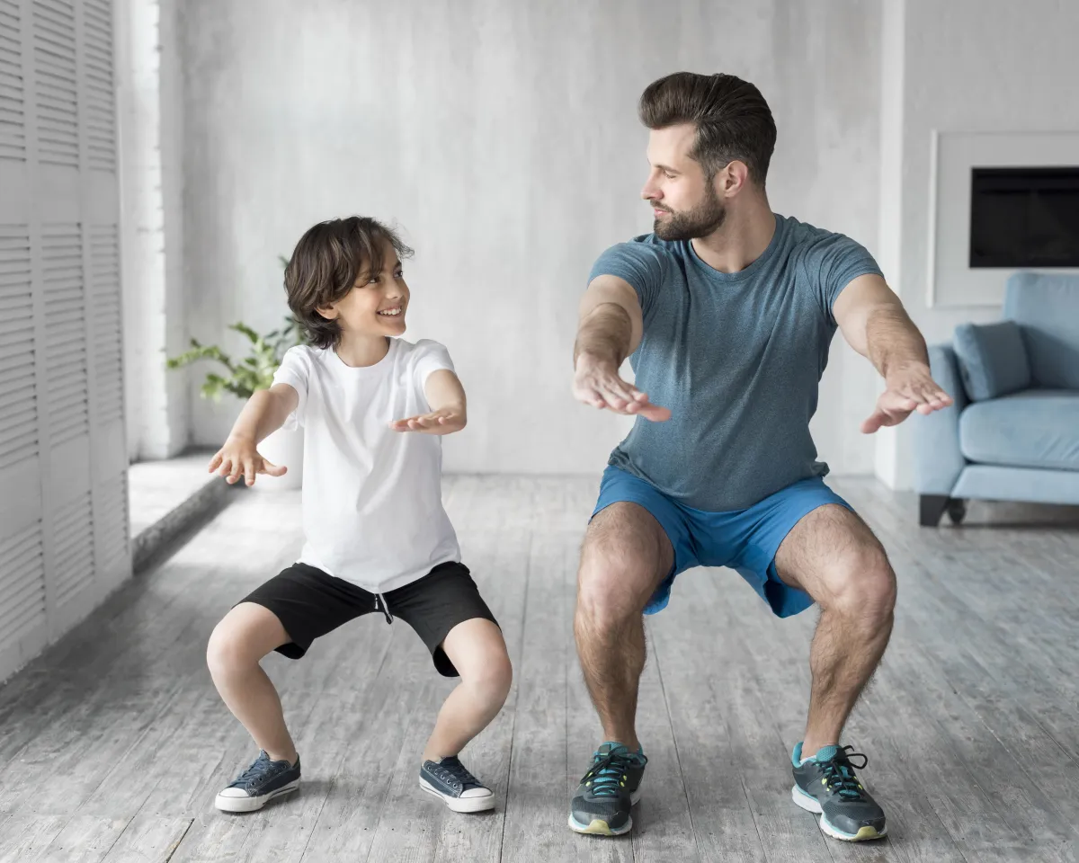 Father and son doing squats during a family workout routine.