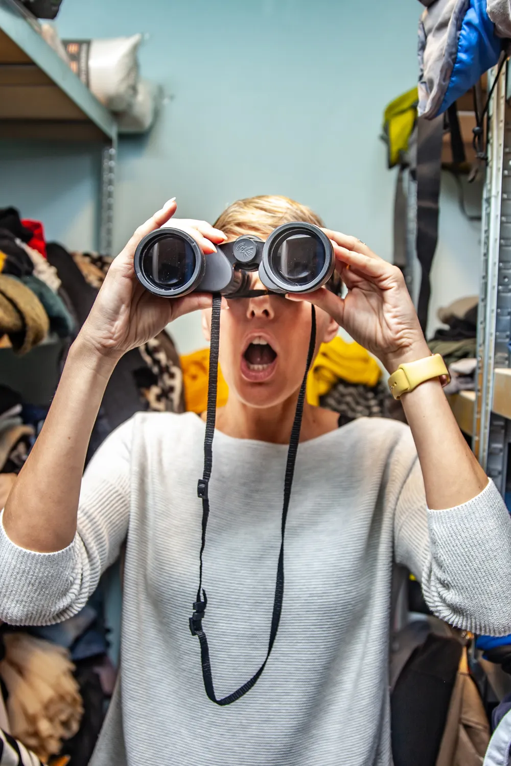 Woman looking for something in a closet and realizing she needs to learn how to declutter a closet.