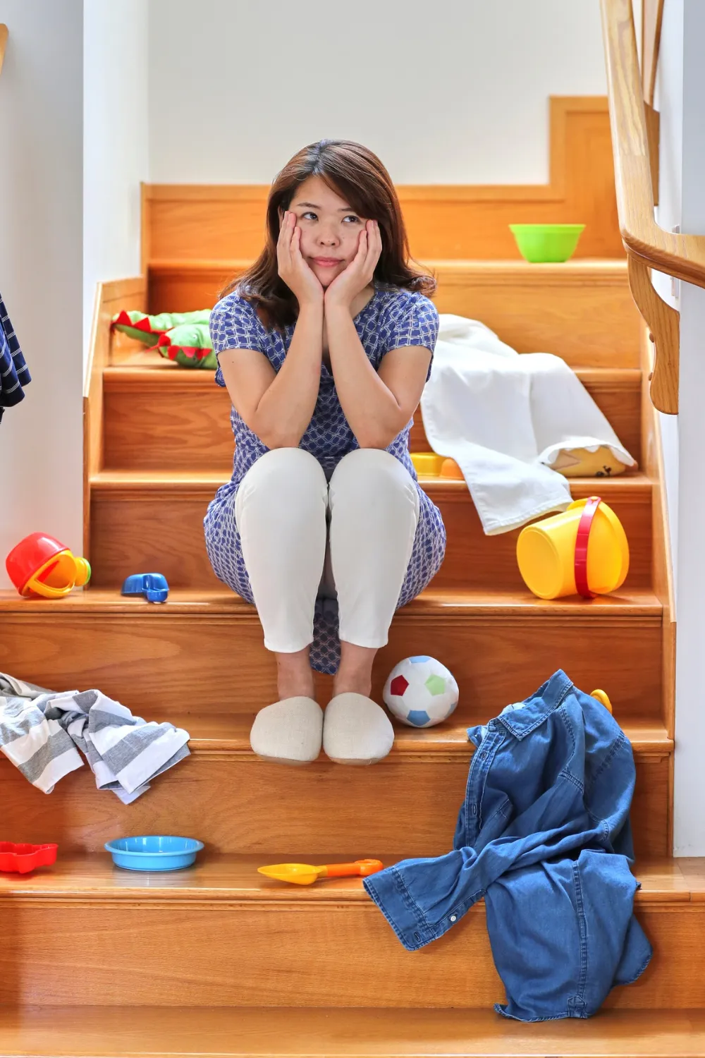 Woman surrounded by stuff wanting to know how to declutter your home fast