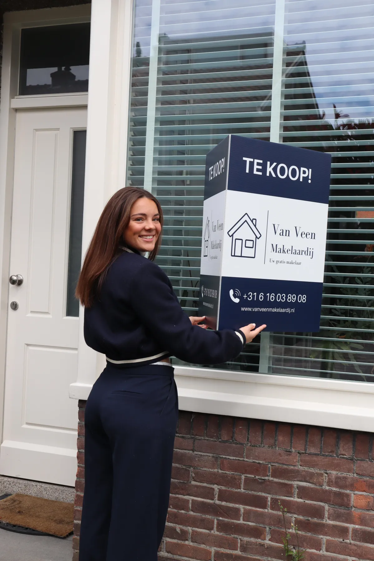 Te koop bord op raam met makelaar