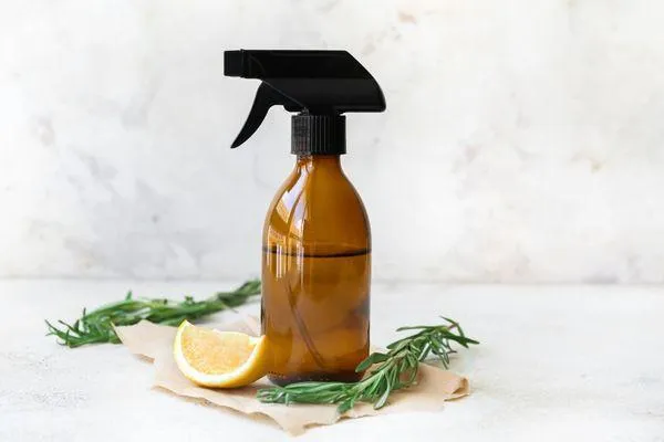 Natural cleaning spray bottle with a fresh lemon, representing simple, healthy swaps for a toxin-free home from the '8 Minutes to Wellness' blog