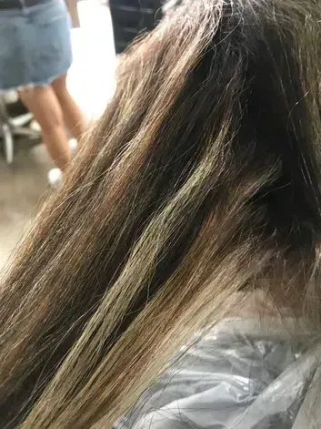 Nell'immagine di copertina, troviamo una foto di capelli castani decolorati, si vede come il decolorante abbia rovinato i capelli rendendoli secchi e sfibrati oltre che giallo aranciati.