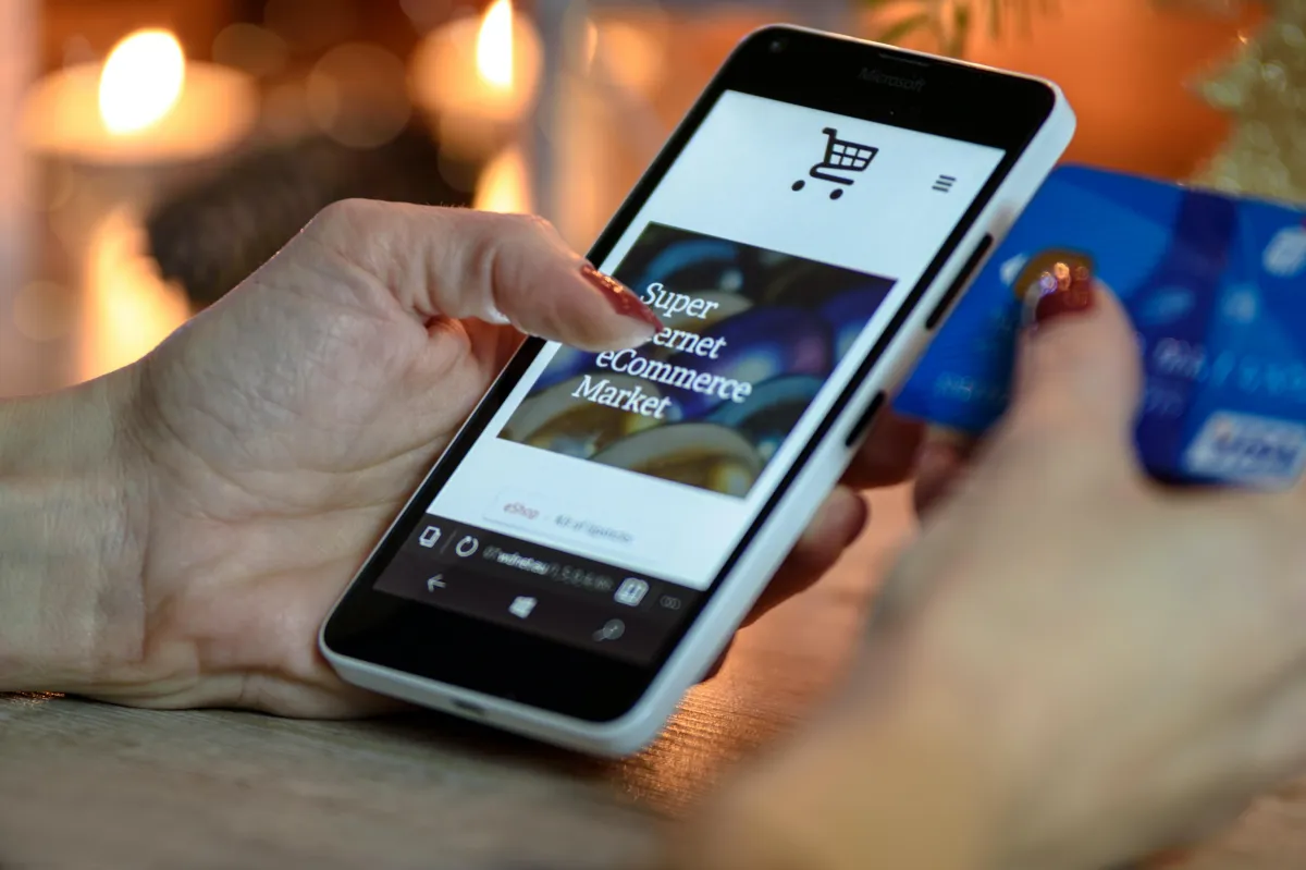 Person with painted nails scrolling on a website on a smartphone.