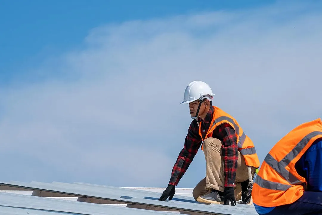 A roofing contractor in action, inspecting a roof.
