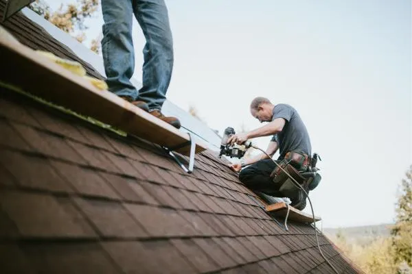 Roofers repairing a residential roof