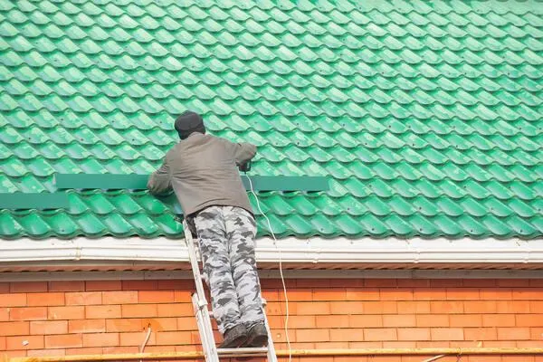 a worker applies roof coatings for added protection and strength against the elements