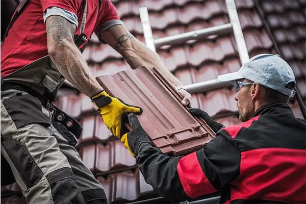 roofers installing red roof tiles