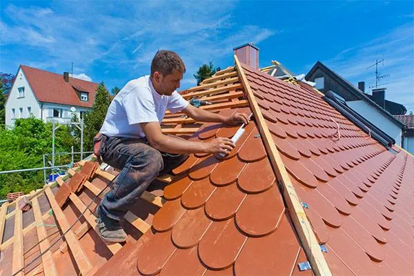 Roofer installing a roofing tile