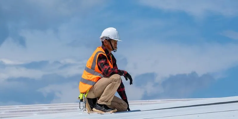 worker inspects the roof for maintenance needs