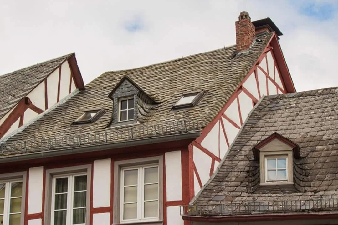 historic house showcases classic roofing style with clay tiles or wooden shingles