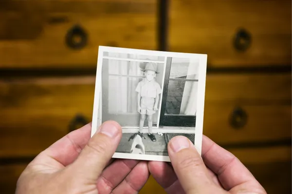 hands holding nostalgic photo of young boy