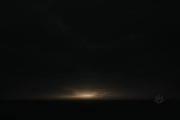 A dark, moody horizon with light breaking through clouds. Symbolizes tension, transition, and clarity emerging from discomfort. 