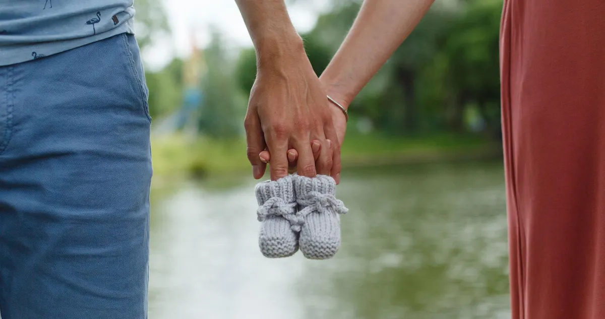 Couple holding baby shoes