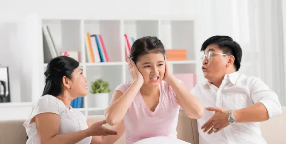 kid plugging ears with parents yellowing