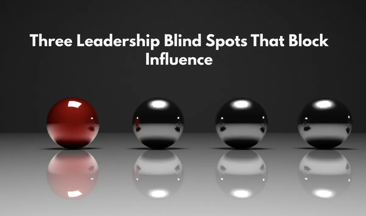Four reflective spheres aligned in a row on a reflective surface, with one red sphere standing apart from three silver spheres. The design represents leadership blind spots, self awareness, difference, and influence.