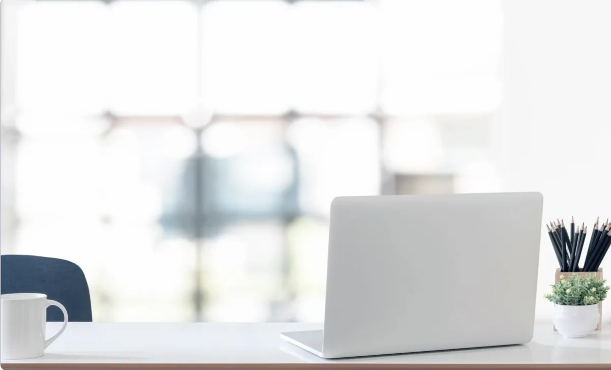 A minimalist desk with a laptop, coffee mug, and pencil holder in front of a bright window. The text above reads: “Before the Year Ends: A Leadership Checkpoint – Five Signals You Are Ready for the Next Level.” The image conveys reflection, growth, and intentional leadership development.