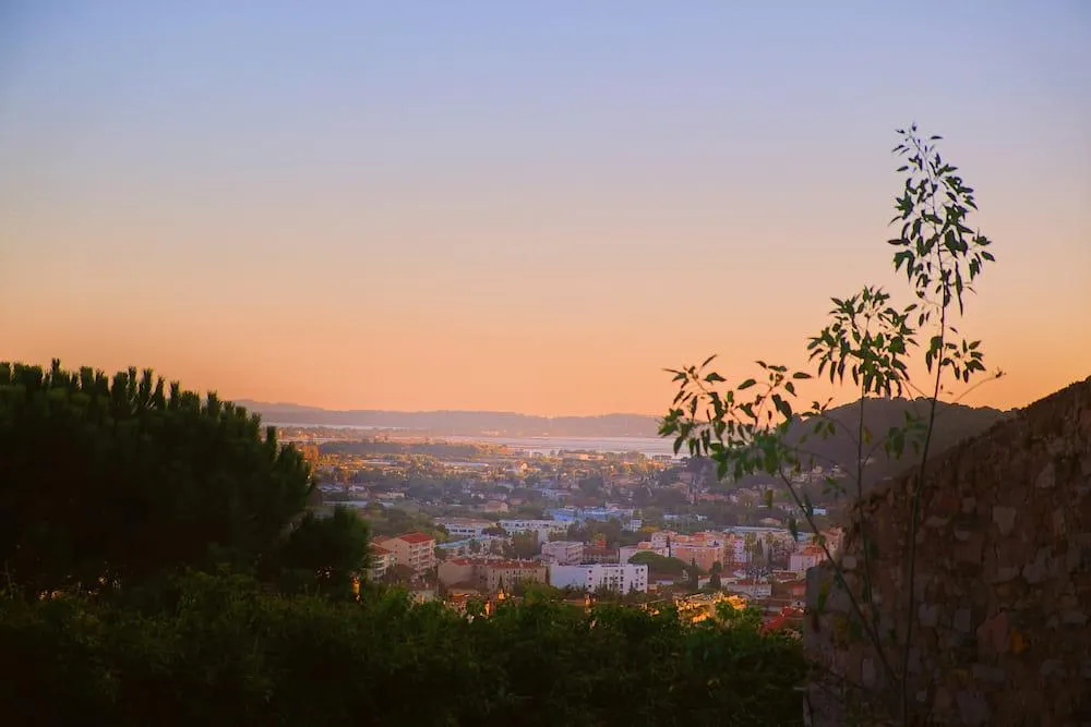 Vue panoramique sur la ville de Hyères au coucher du soleil, avec un paysage méditerranéen et une atmosphère paisible.