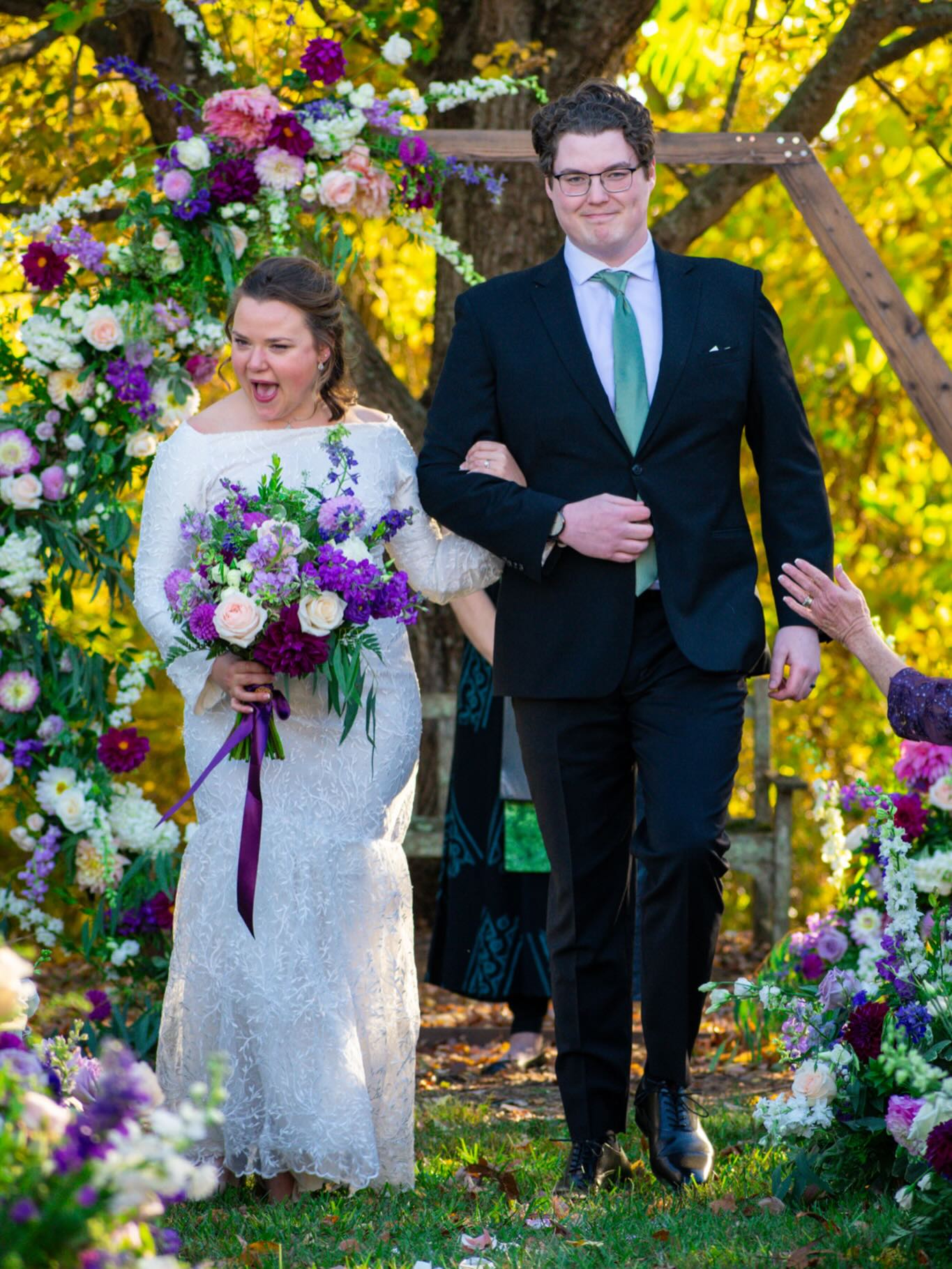 Fall wedding ceremony with a floral arch and seasonal bouquet featuring dahlias, roses, and greenery in the New River Valley