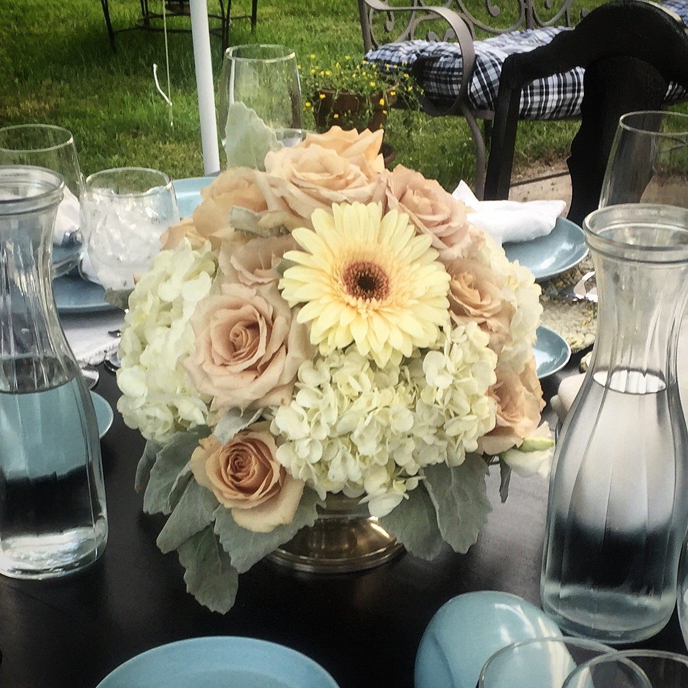 Dinner centerpiece with blush pink roses, white hydrangea, cream Gerber daisey in a silver footed compote