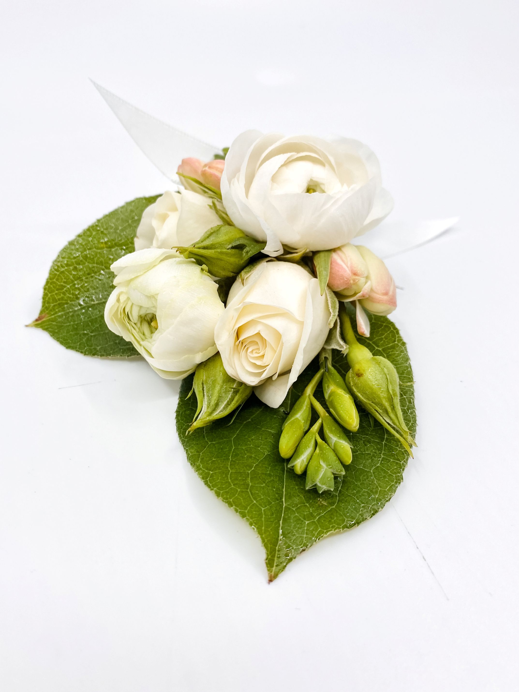 Companion groom's boutonniere to a fragrant bridal bouquet, made with tuberose, spray rose, ranunculus, and lemon leaf.
