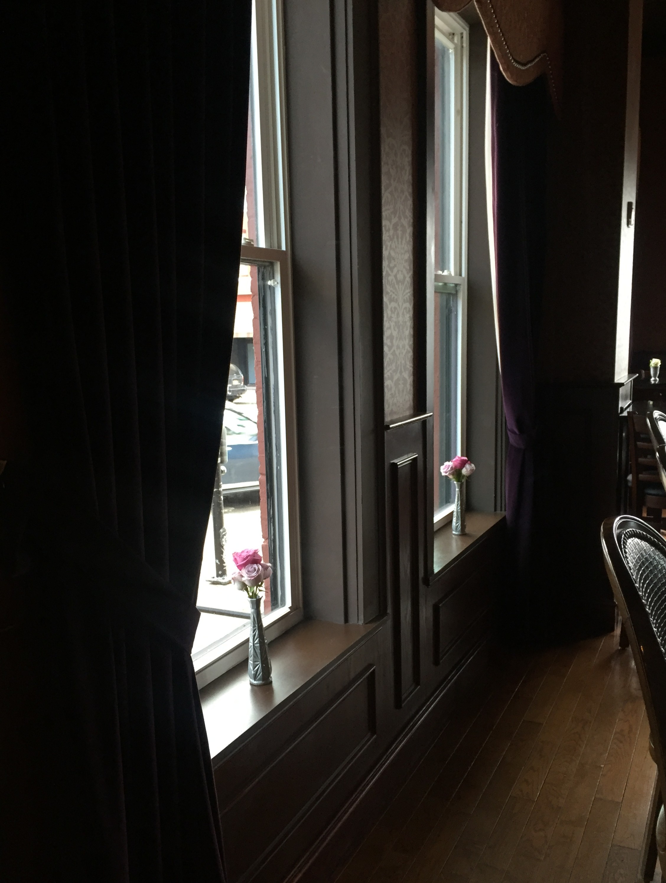 Purple and lavender roses in bud vases in bar windows