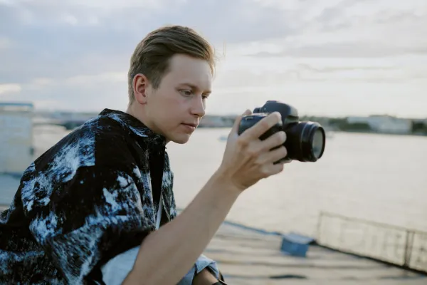 A picture of a person capturing a scenic view with a camera or a person setting up videography equipment.