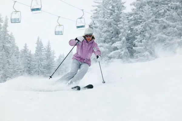 A picture of a person enjoying snow sports like skiing or snowboarding or a person organizing winter gear.