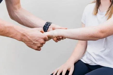 physio examines wrist
