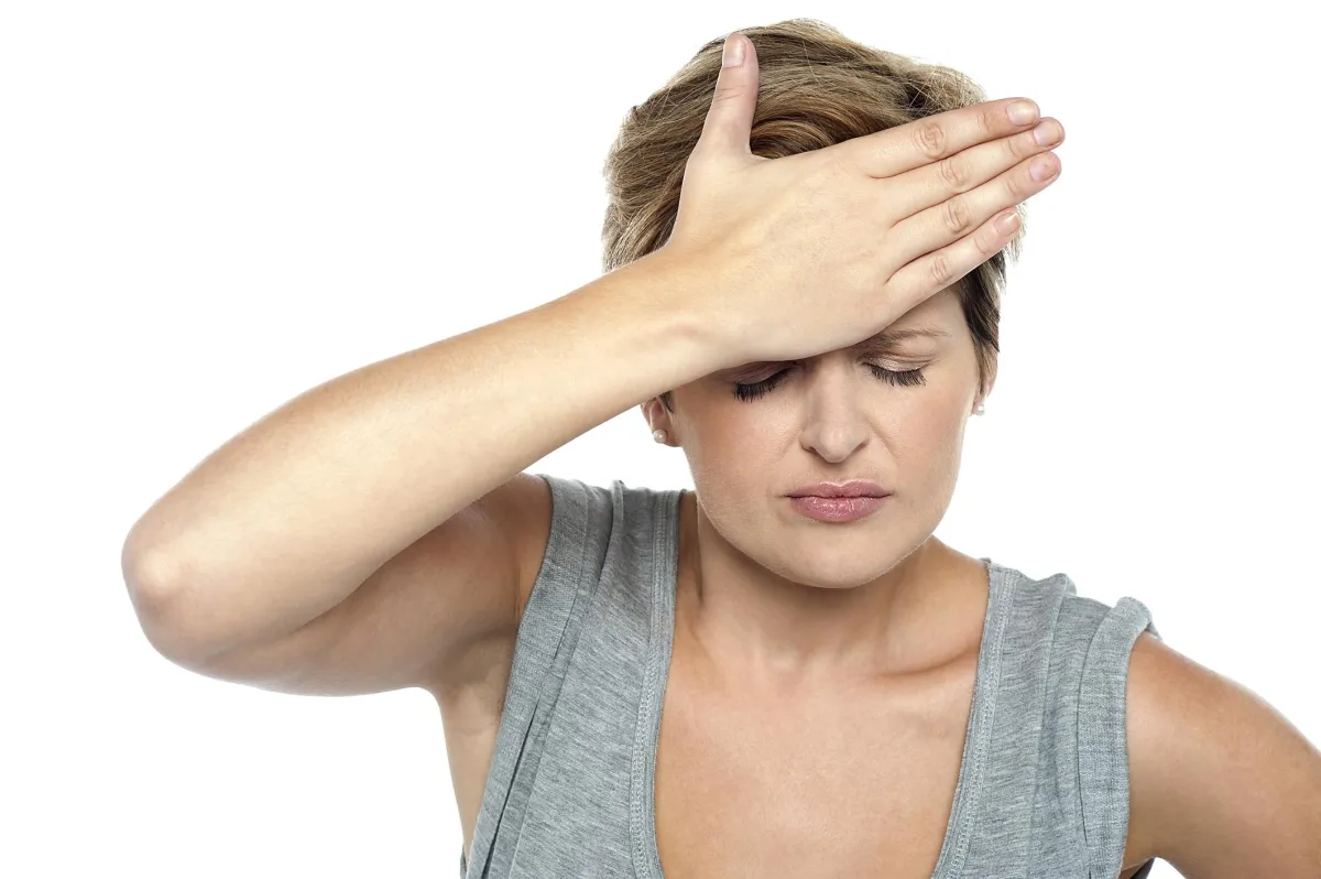 woman holding palm on forehead