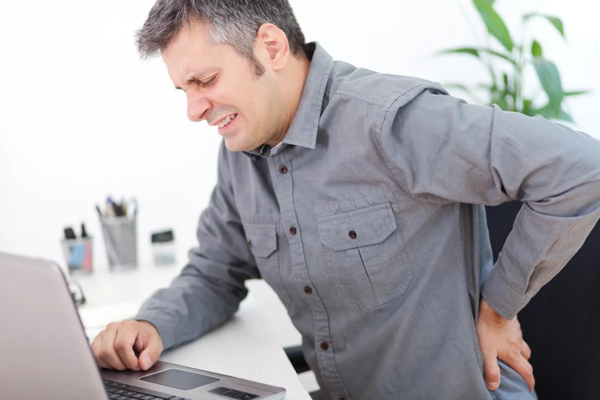man touching painful lower back