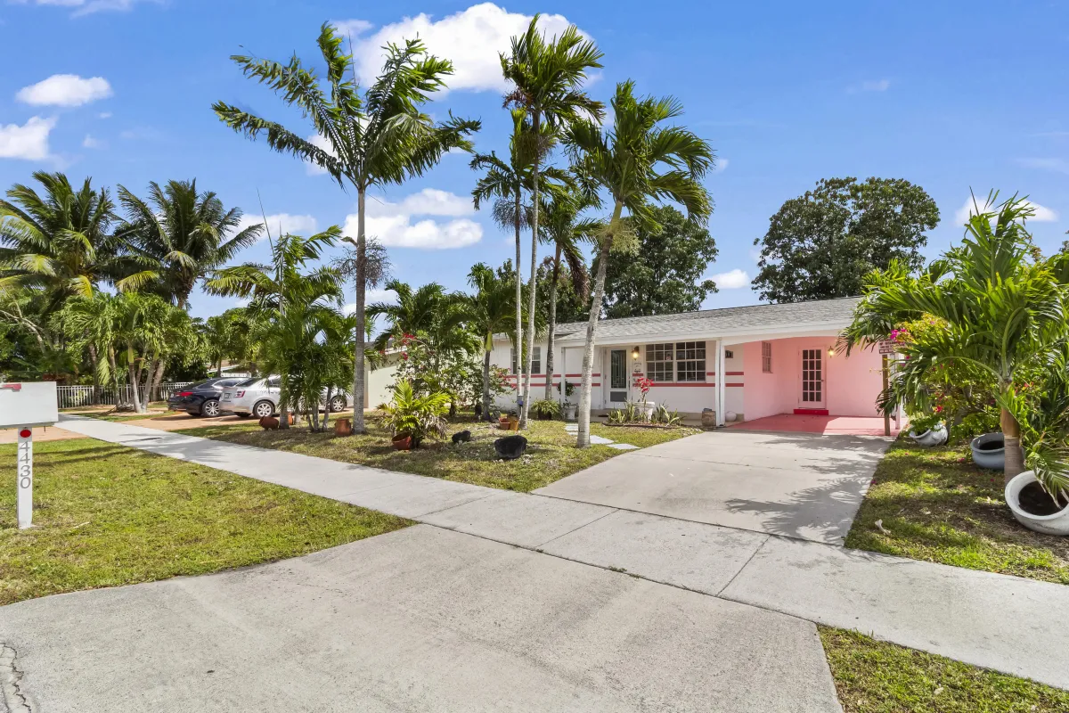 Front exterior view of a single-family home at 4430 NW 62nd Street, North Lauderdale, FL 33319, featuring a carport, driveway, and well-kept front yard. Sold by Hansel Duran Realtor at LoKation Real Estate