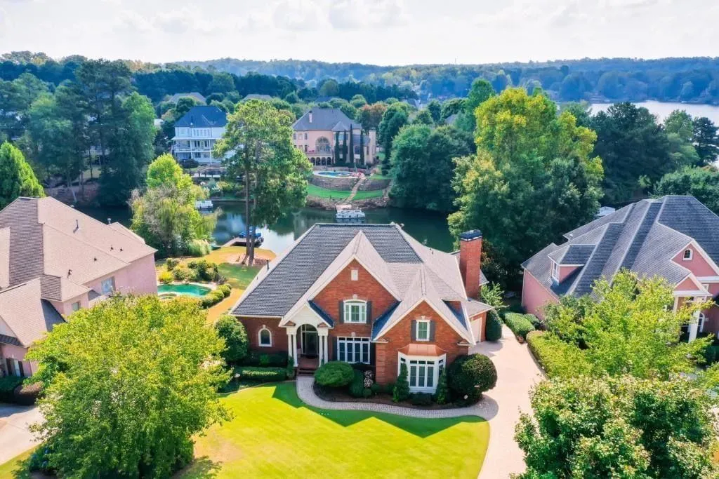 Luxury gated entrance with landscaped drive and security booth in Alpharetta, Georgia