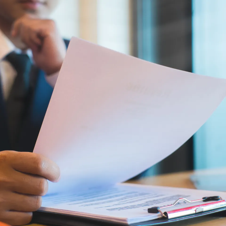 Focused man reviewing plans or documents, representing the strategic process of pricing a home to sell quickly without sacrificing profit.