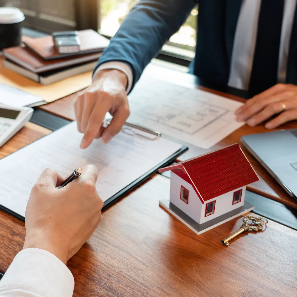 First-time homebuyers writing 2023 goals on a checklist with a house icon and calendar in the background.