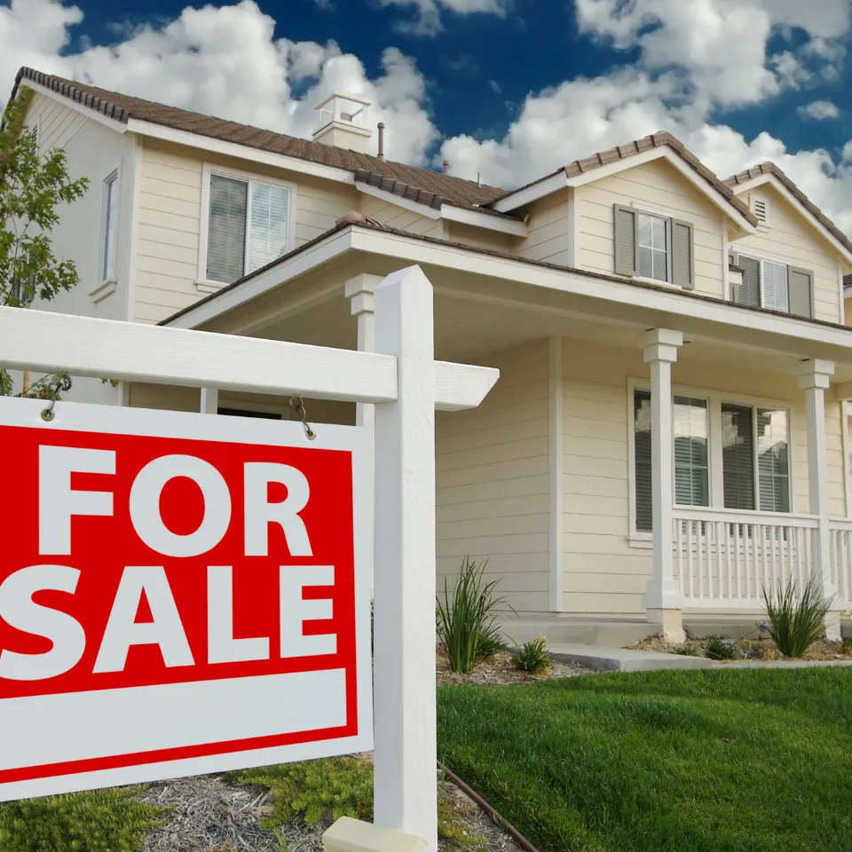 Well-staged home with a “For Sale” sign, spring flowers, and buyers touring during a sunny open house.