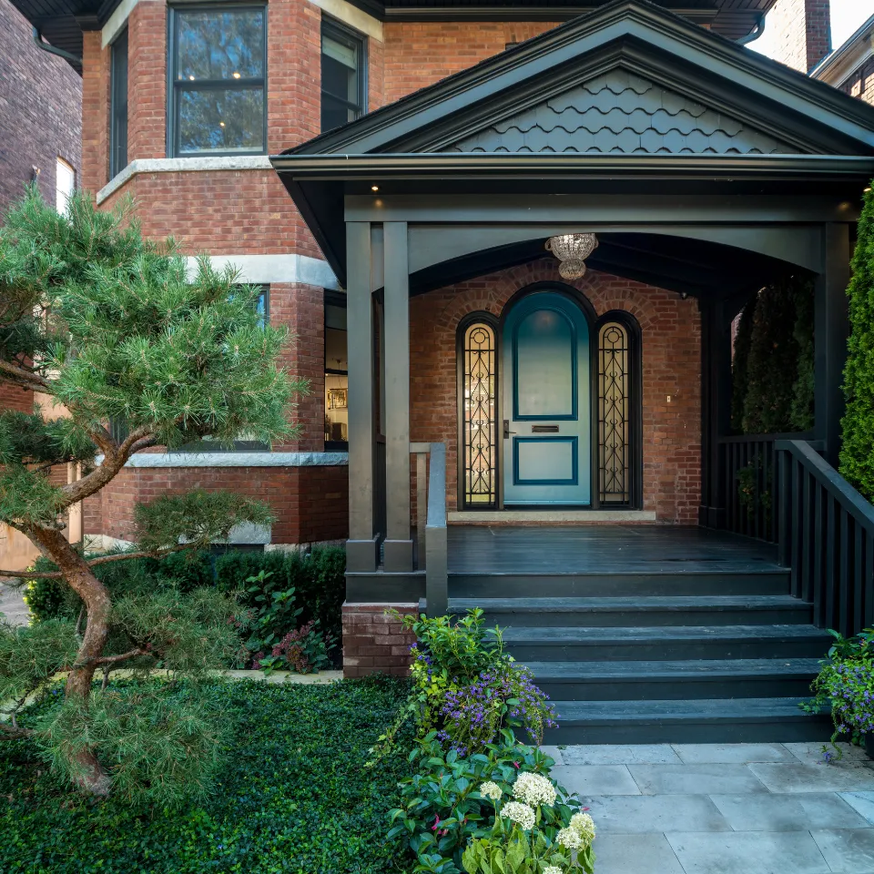 Modern home entrance with stone walkway, custom door, and landscaped yard.
