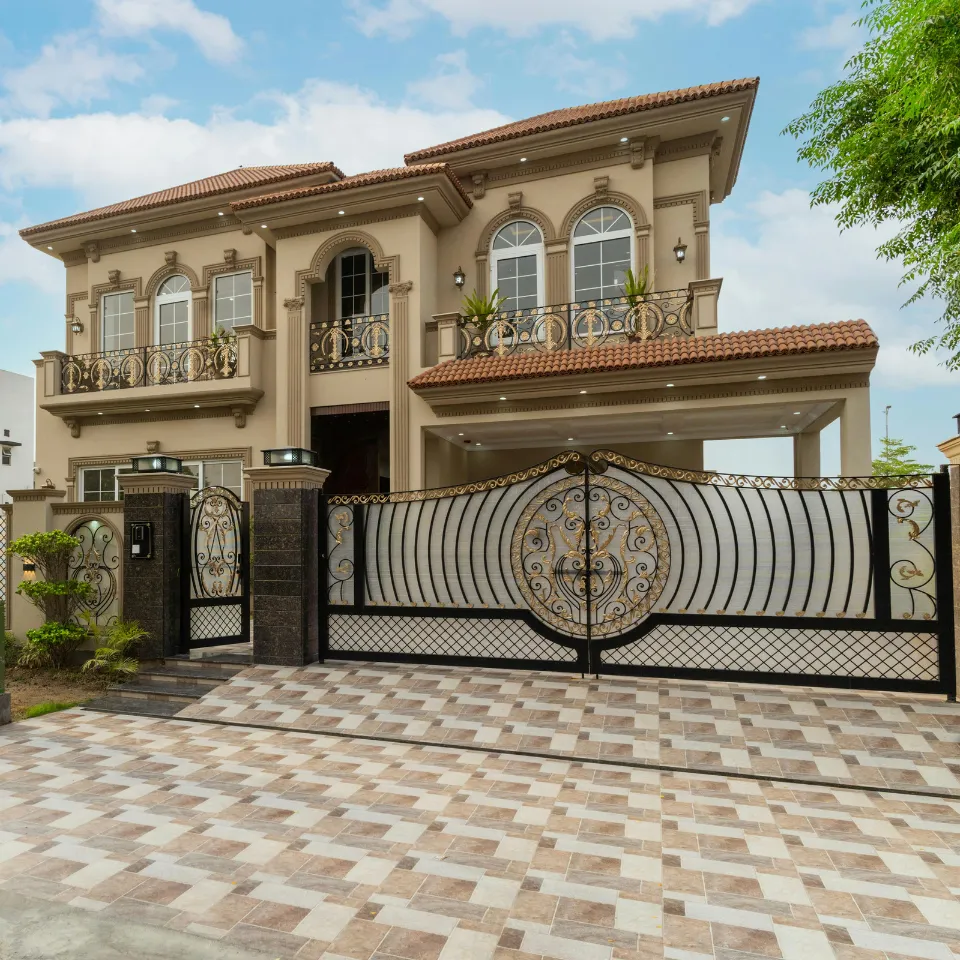 Luxury home with gated entrance, security cameras, and well-lit exterior at night.