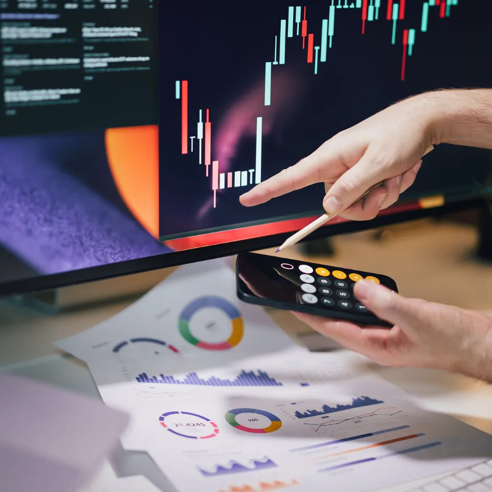 Economist reviewing housing affordability data and mortgage charts on a laptop, highlighting rising interest rates and income comparisons in 2025.