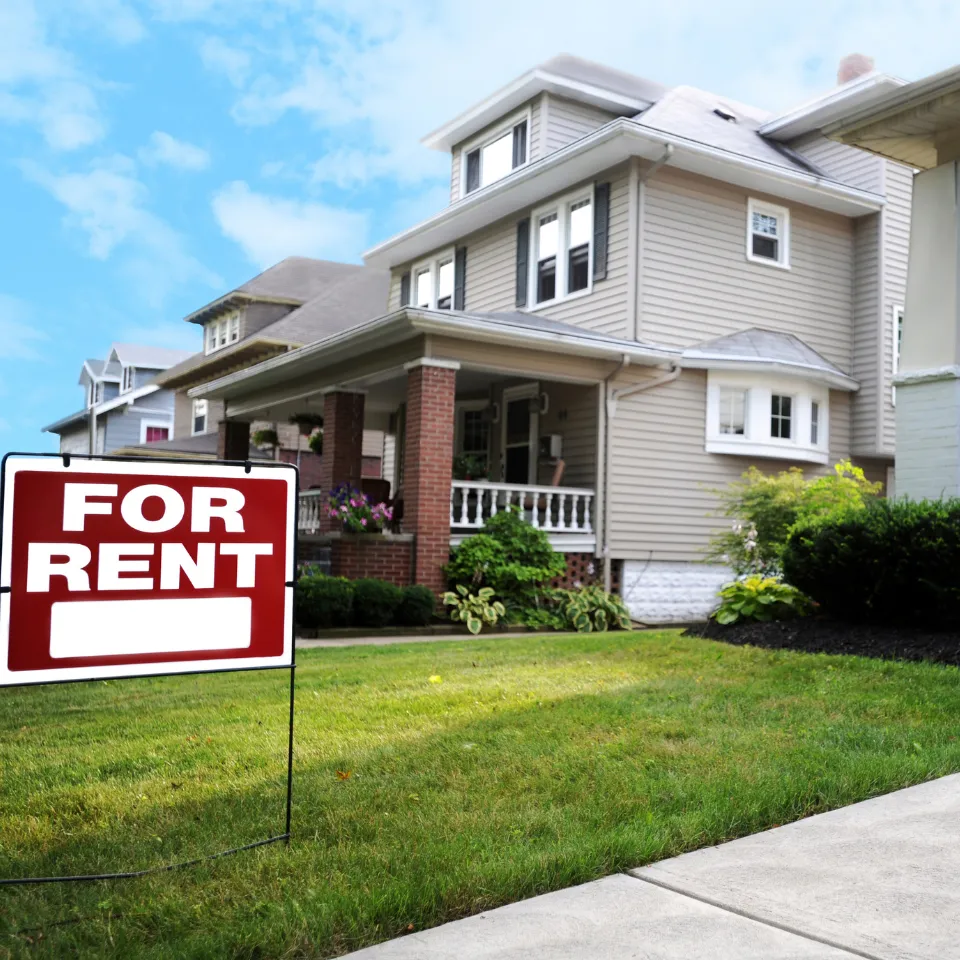 Vacation home with 'For Rent' sign and scenic background, symbolizing rental investment.