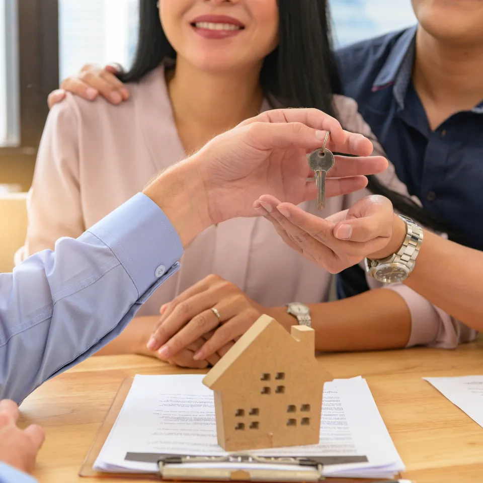 Real estate agent presenting pricing strategy charts to homeowners at a kitchen table.