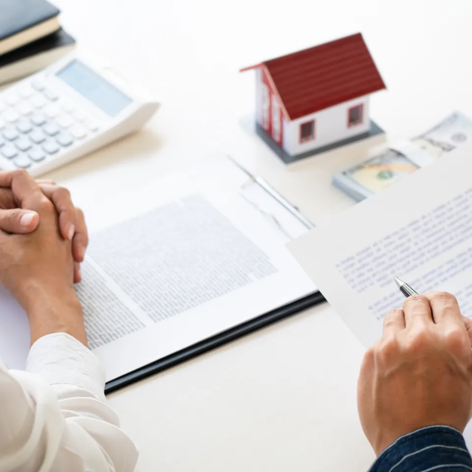 Home buyers and sellers meeting with a real estate agent to discuss changes from the 2025 NAR settlement.