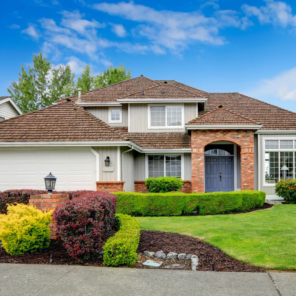 Luxury home exterior with manicured hedges and professionally landscaped front yard enhancing curb appeal.